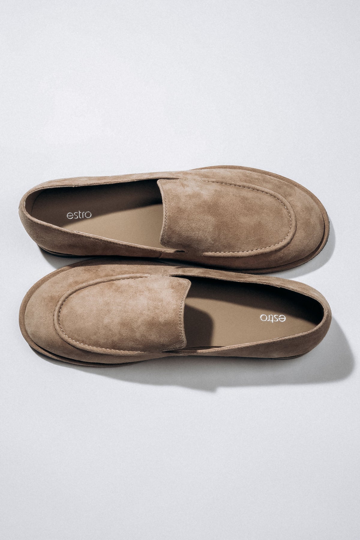 Draufsicht auf das Paar beiger Damen-Loafer aus weichem Naturvelours.