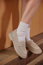 Seitenansicht eines beigen Penny-Loafers für Damen.