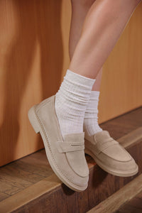 Seitenansicht eines beigen Penny-Loafers für Damen.
