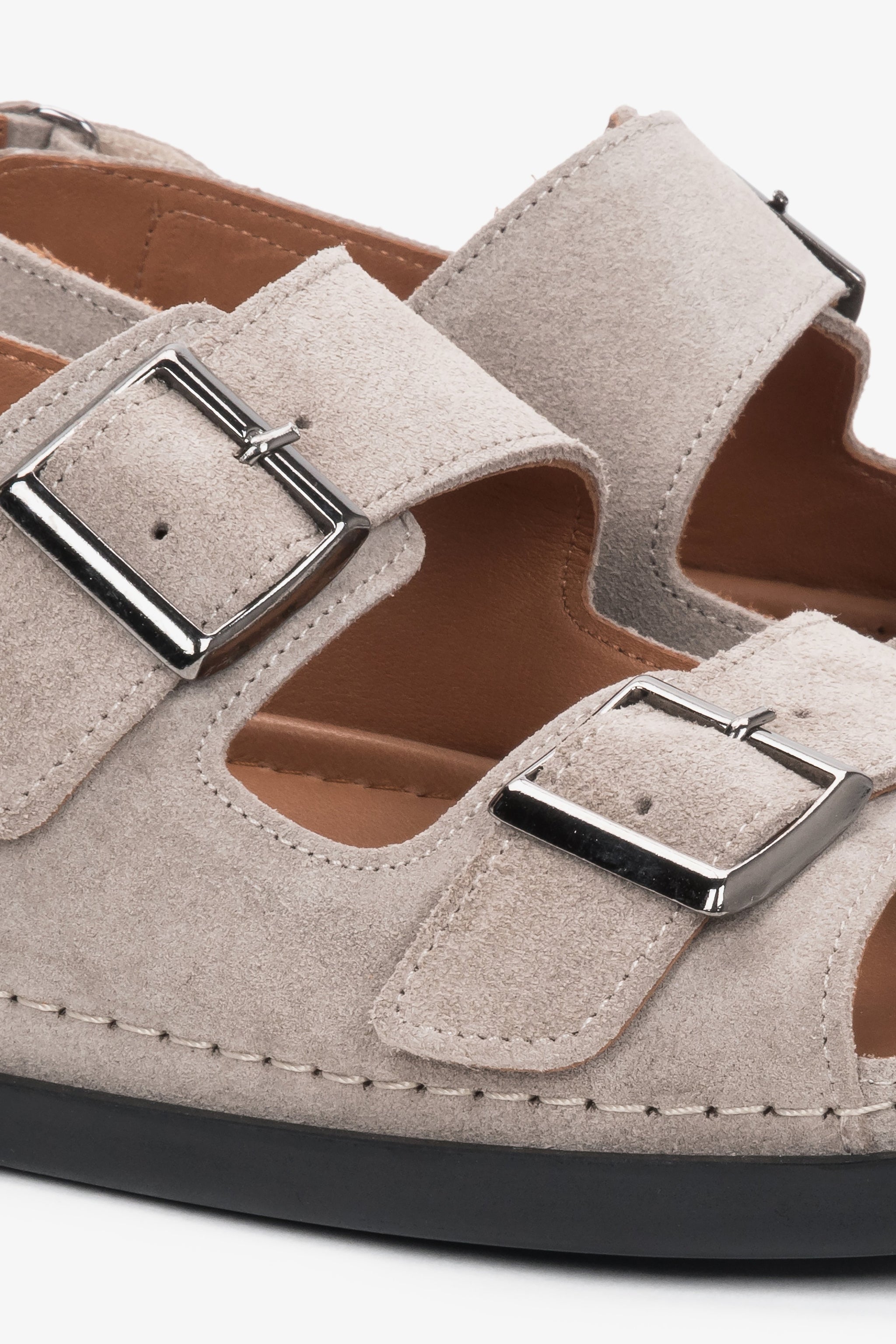 Detailansicht der verstellbaren Riemen der beigen Veloursleder-Sandalen