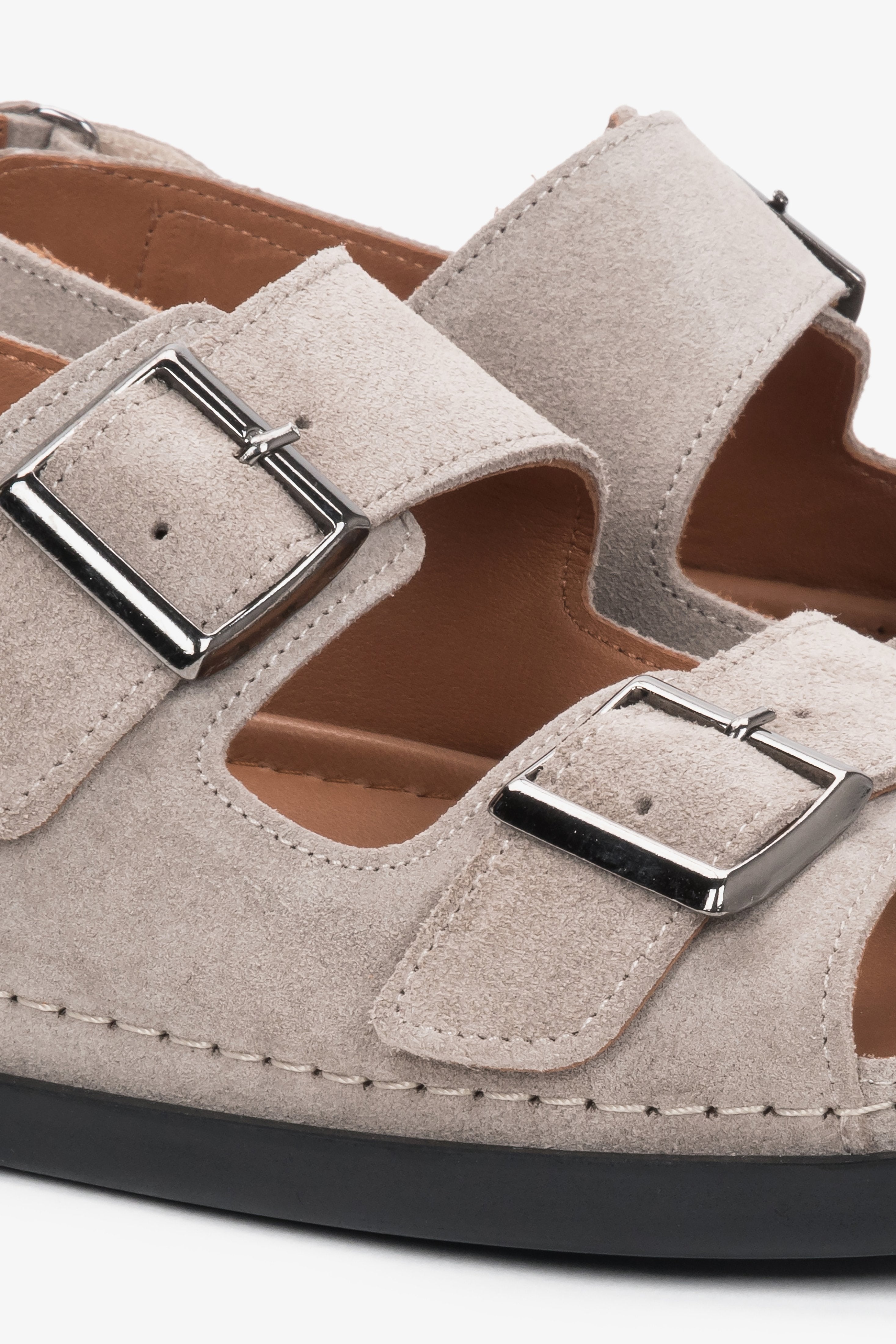Detailansicht der verstellbaren Riemen der beigen Veloursleder-Sandalen