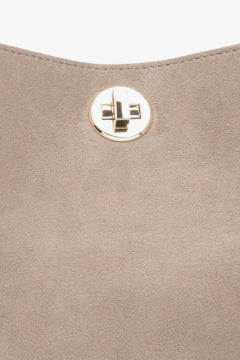 Ein Detailfoto des Verschlusses einer beigefarbenen Damenhandtasche von Estro