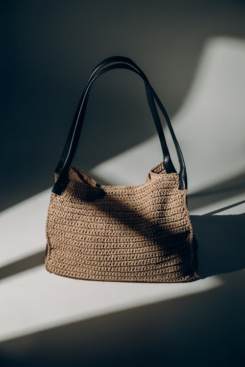 Beige Damen-Shopper-Tasche aus Stroh in künstlerischer Ansicht mit schwarzen Henkeln