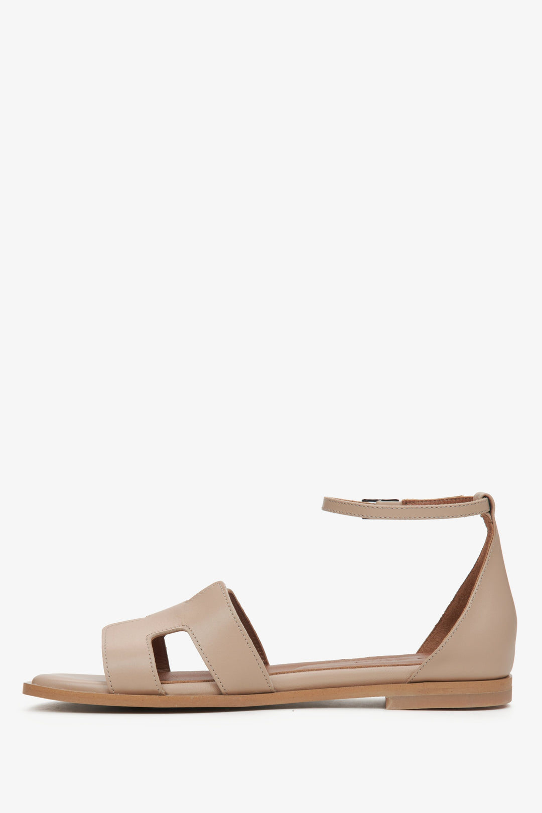 Beige Ledersandale für Damen in der Seitenansicht, die die Riemen und die Sohlenkonstruktion zeigt.