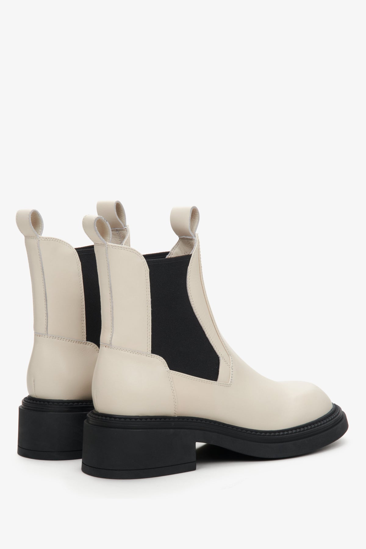 Schräge Rückansicht, die die Zuglaschen und die Fersenpartie der beige-schwarzen Boots zeigt