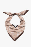 Frontalansicht des beige-weiß-braunen Damen-Halstuchs von Estro, das elegant zu einem voluminösen Knoten gebunden ist