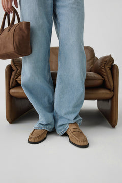 Detailansicht der beigefarbenen Loafer getragen zu hellblauen Jeans und einer braunen Tasche