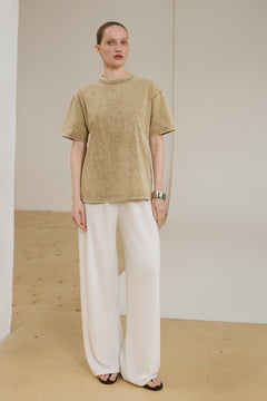 Model in voller Länge mit beigem Boxy-T-Shirt und weißer Hose