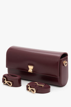 Bordeauxrote Damen-Clutch präsentiert neben ihren zwei abnehmbaren Echtleder-Riemen