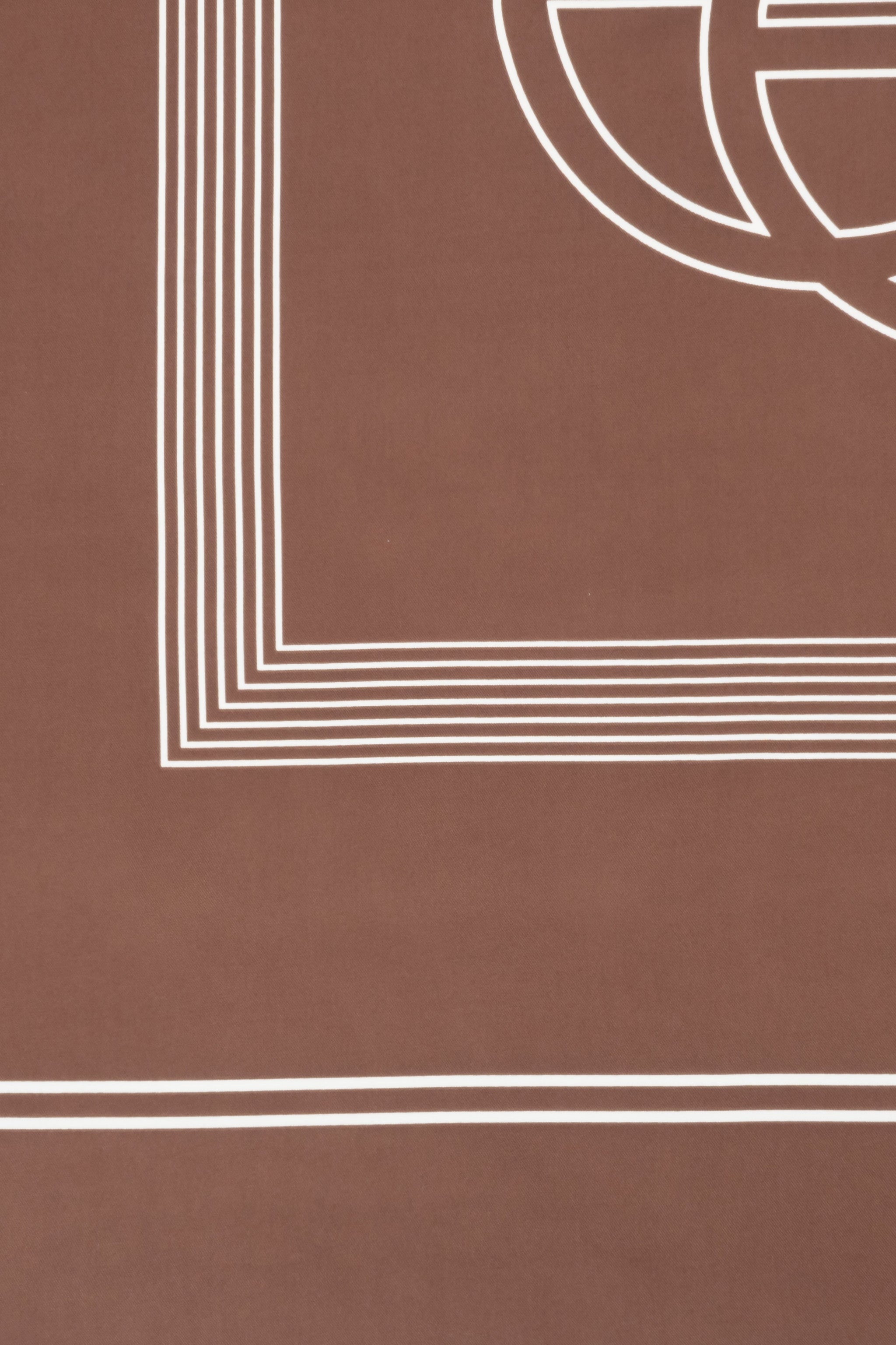 Detailaufnahme des edlen braunen Satinstoffs mit feinem weißen Linienmuster und Markenlogo 