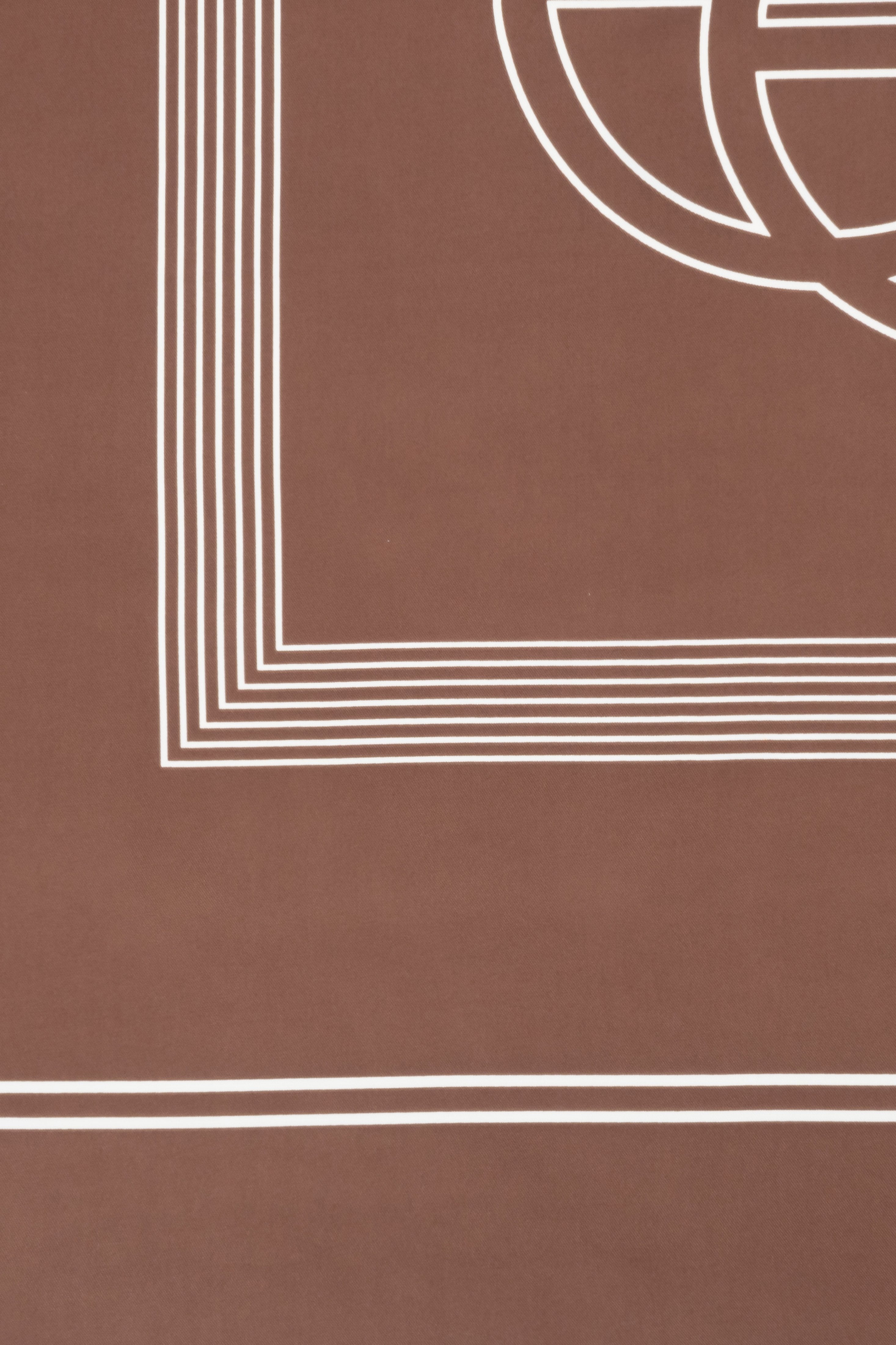 Detailaufnahme des edlen braunen Satinstoffs mit feinem weißen Linienmuster und Markenlogo 