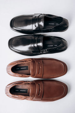 Elegante Anordnung der braunen und schwarzen Mokassins von Estro Selection.