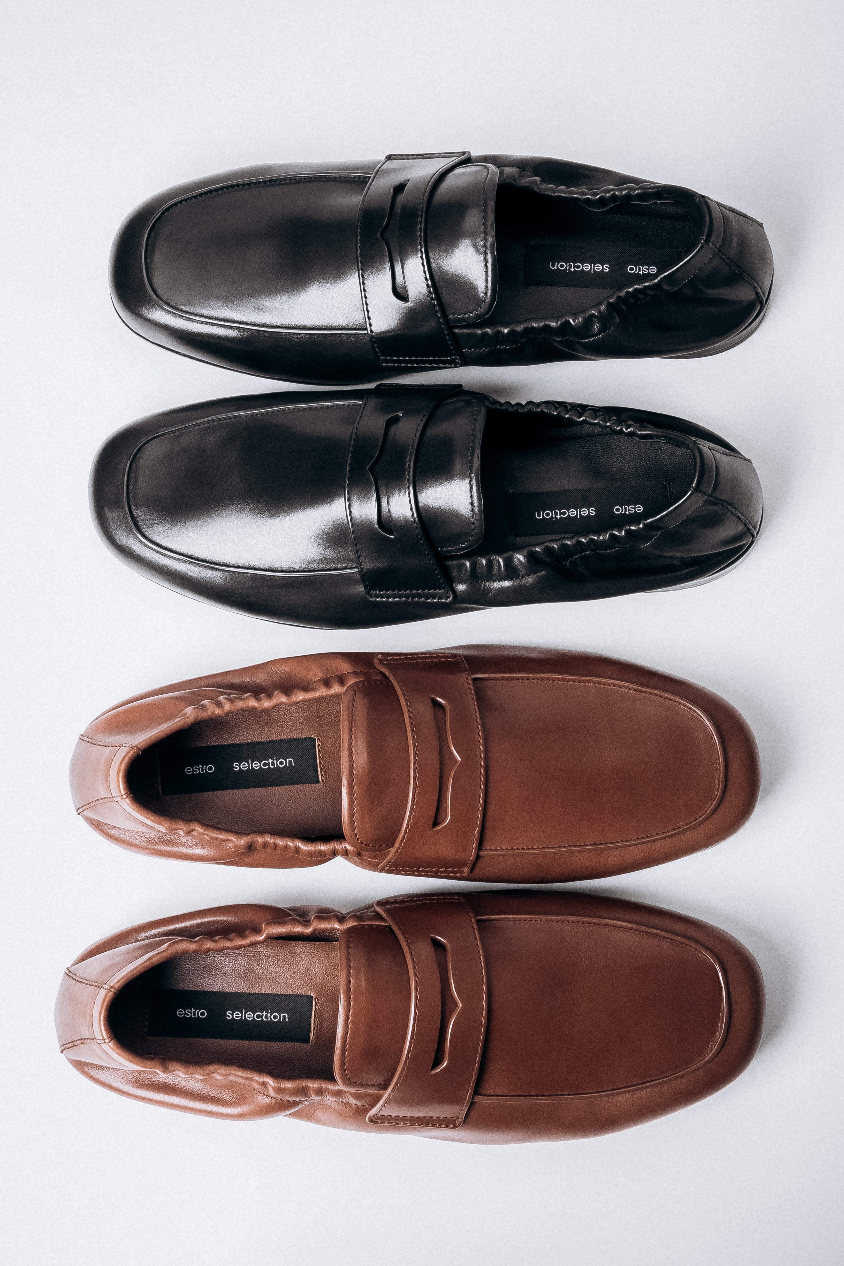 Elegante Anordnung der braunen und schwarzen Mokassins von Estro Selection.