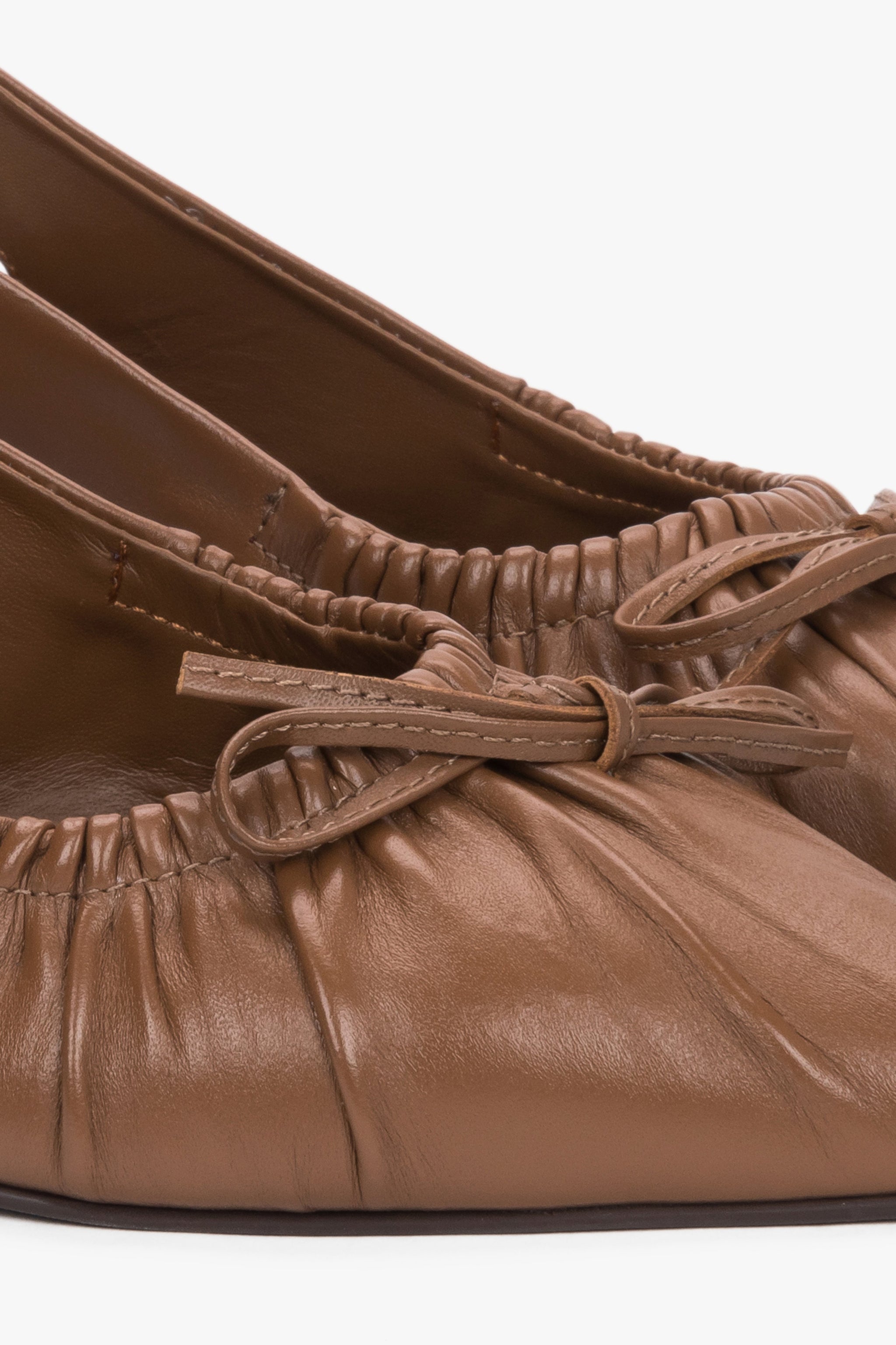 Detailaufnahme brauner Damen-Slingback-Pumps aus Leder mit gerafften Kanten und Schleife