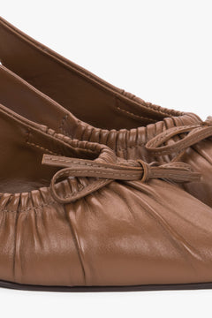 Detailaufnahme brauner Damen-Slingback-Pumps aus Leder mit gerafften Kanten und Schleife