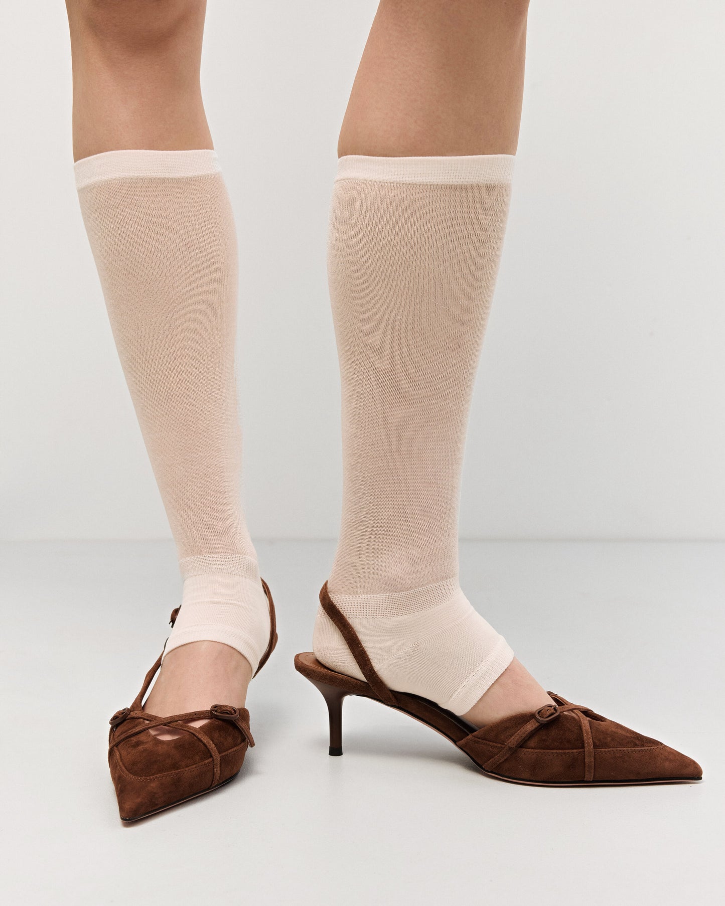 Estro braune Slingback-Pumps mit niedrigem Absatz für Damen – am Fuß präsentiert.