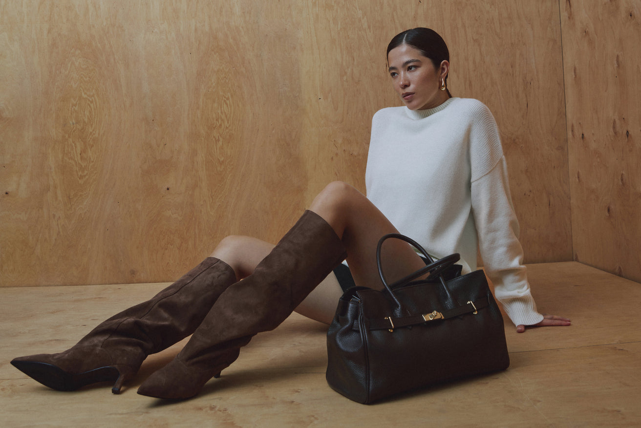Model sitzt auf dem Boden und setzt die bequemen braunen Slip-on-Stiefel lässig in Szene 