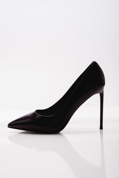 Klassische Seitenansicht des schwarzen Damen-Stilettos aus Lackleder auf weißem, reflektierendem Untergrund