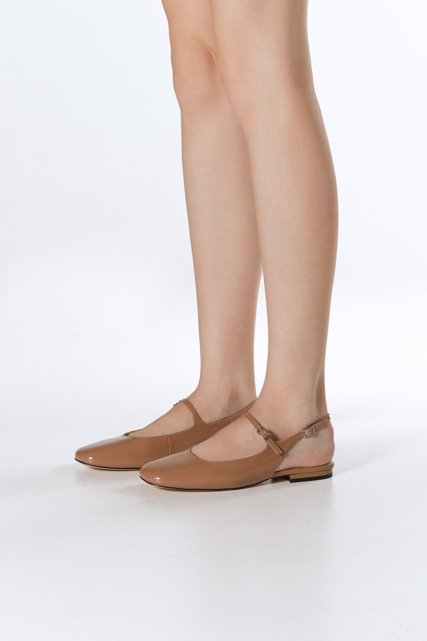 Estro Slingback-Ballerinas aus braunem Lackleder – Präsentation am Fuß.