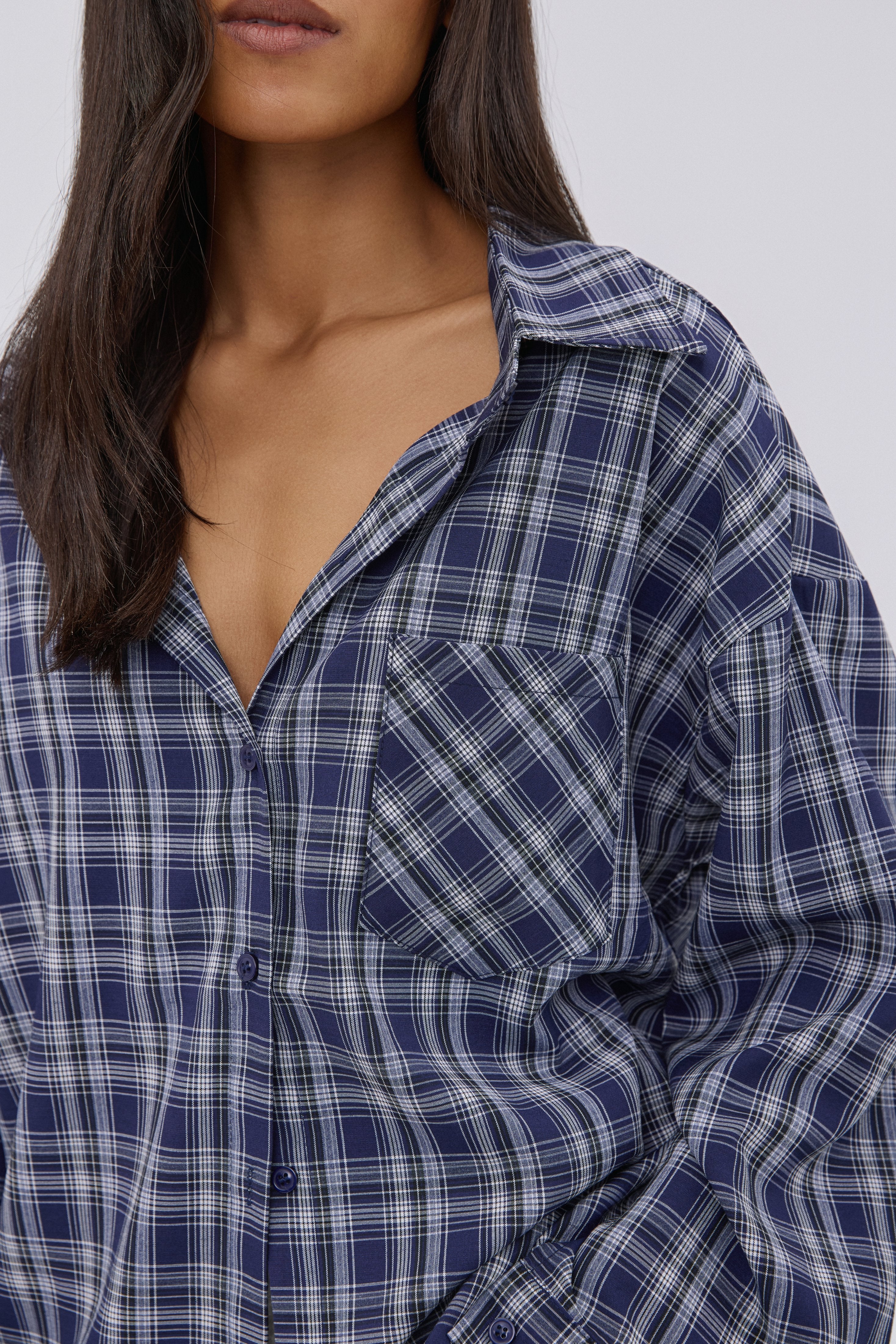 Detailaufnahme des dunkelblauen Karomusters, der Knopfleiste und der Brusttasche der Damen-Hemdbluse