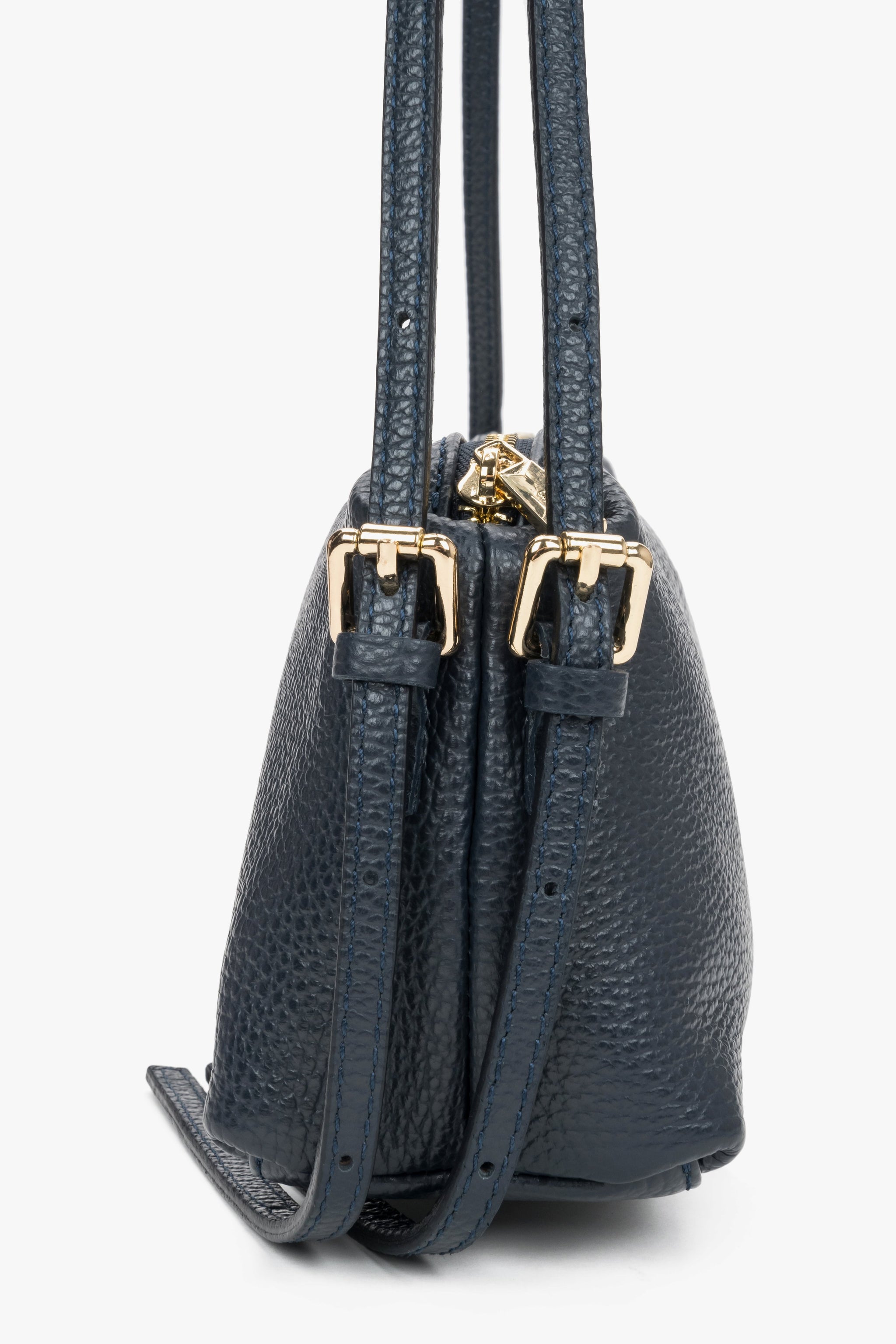 Seitliche Ansicht der Tasche mit Fokus auf die doppelten Riemenhalterungen und goldenen Beschläge 