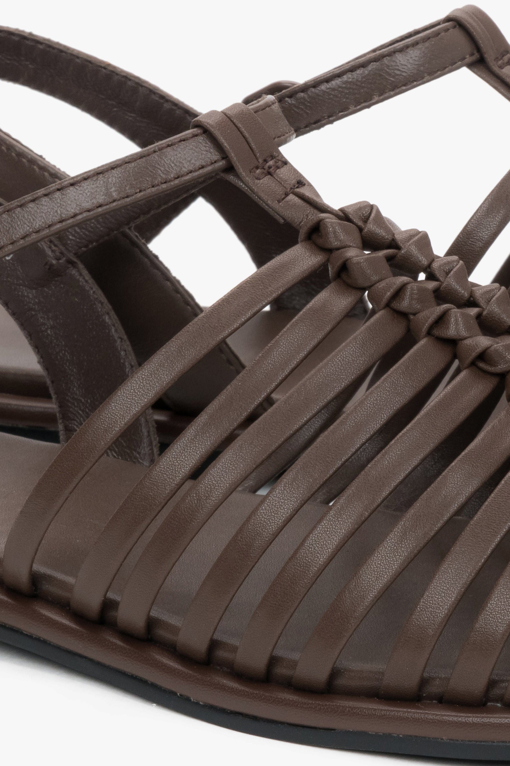 Nahaufnahme der kunstvoll geflochtenen Echtleder-Riemen an der geschlossenen Schuhspitze.