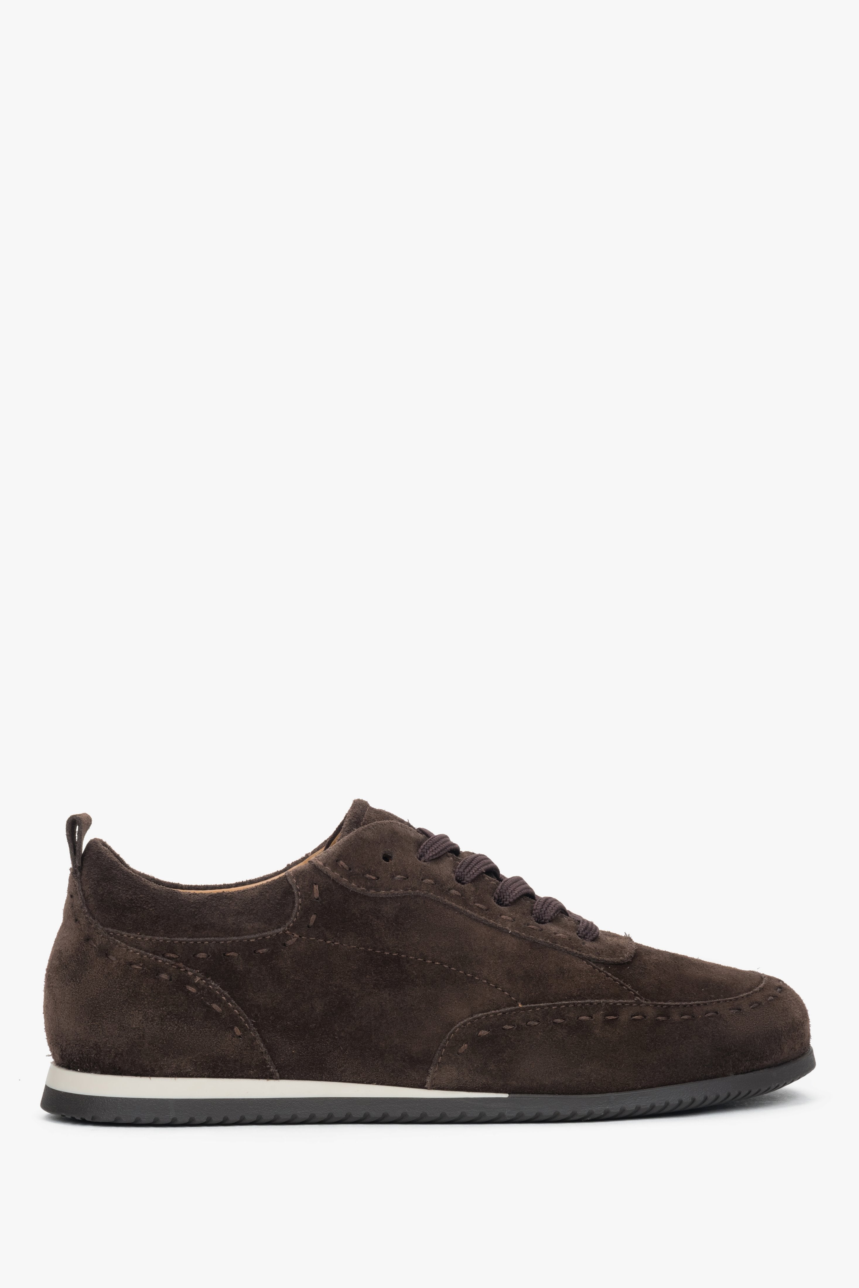 Seitenansicht des rechten Sneakers, die die flache, weiße Sohle und das braune Veloursleder zeigt.