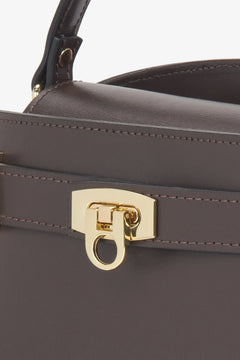Nahaufnahme des eleganten, goldenen Schnallenverschlusses auf dem dunkelbraunen italienischen Leder 