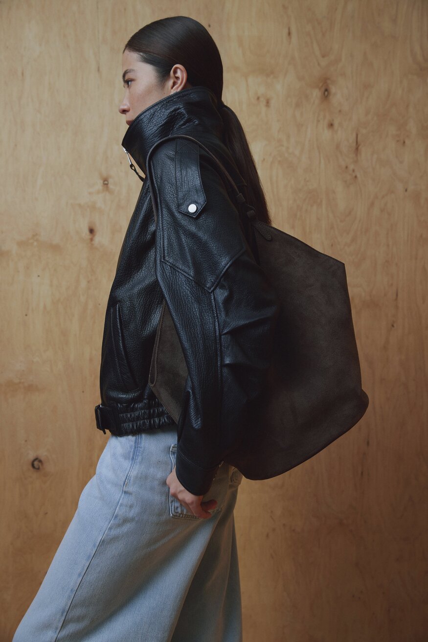 Model in schwarzer Jacke trägt die dunkelbraune Hobo-Tasche über der Schulter