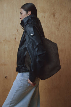Model in schwarzer Jacke trägt die dunkelbraune Hobo-Tasche über der Schulter