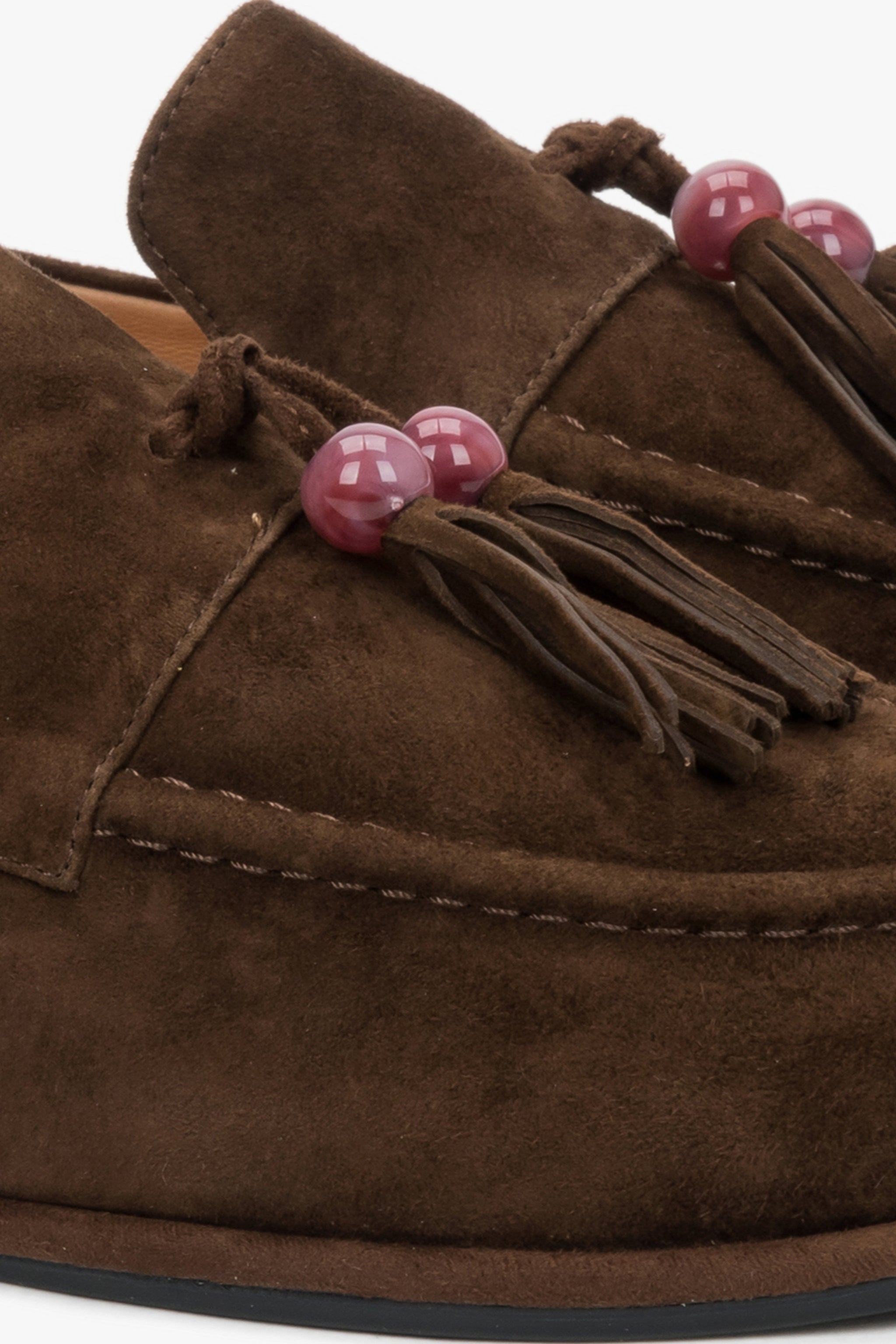 Detailaufnahme der dekorativen Quaste mit Perle auf dem dunkelbraunen Velours-Loafer