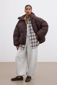 Frontalansicht der dunkelbraunen Damen-Oversize-Jacke, lässig offen getragen über einem hellen Outfit 