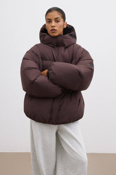 Model in der geschlossenen dunkelbraunen Oversize-Winterjacke mit voluminöser Steppung 