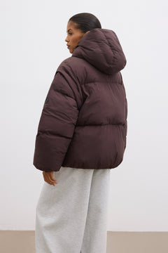Rückansicht der dunkelbraunen Steppjacke, präsentiert an einem Model im urbanen Look 