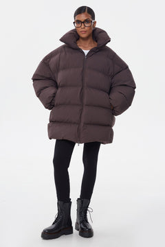Ganzkörperansicht der dunkelbraunen gesteppten Pufferjacke für Damen im Stehen
