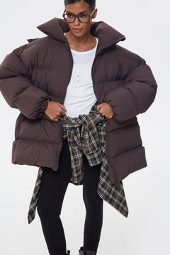 Präsentation der dunkelbraunen Daunenjacke mit kariertem Accessoire um die Taille