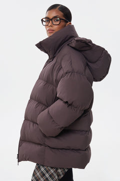 Seitliches Profil der weiten dunkelbraunen Oversize-Winterjacke mit Kapuze