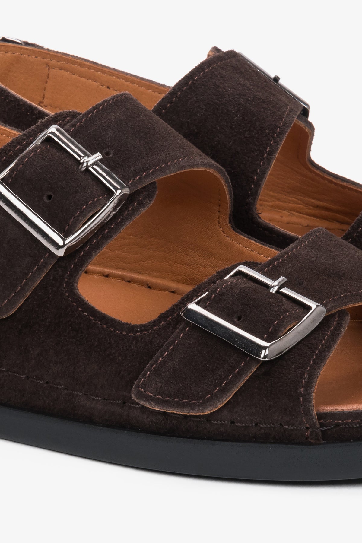 Detailansicht der verstellbaren Riemen und Zierschnallen der dunkelbraunen Veloursleder-Sandalen