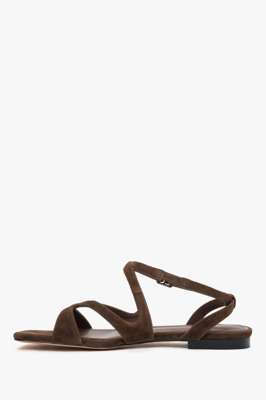 Linkes Seitenprofil der braunen Sandalen mit gekreuzten Riemen iund flachem Absatz.