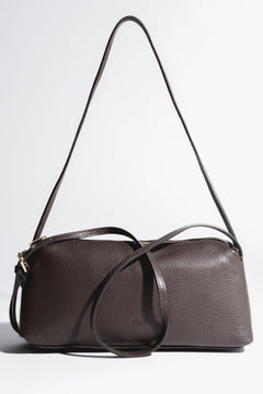 Frontale Ansicht der dunkelbraunen Ledertasche, die die horizontale Silhouette zeigt 