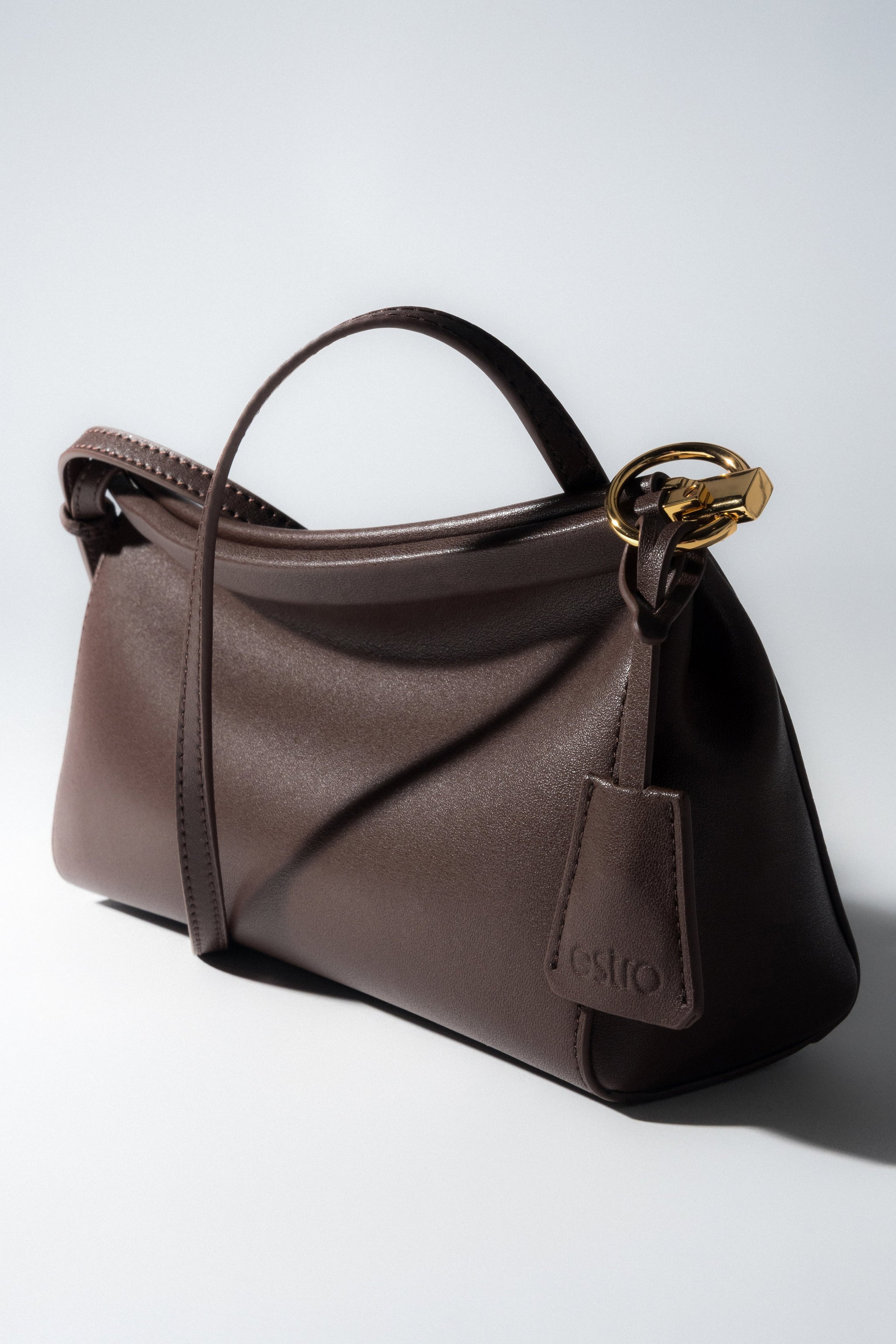 Detailaufnahme der goldenen Beschläge an der dunkelbraunen Estro Handtasche.