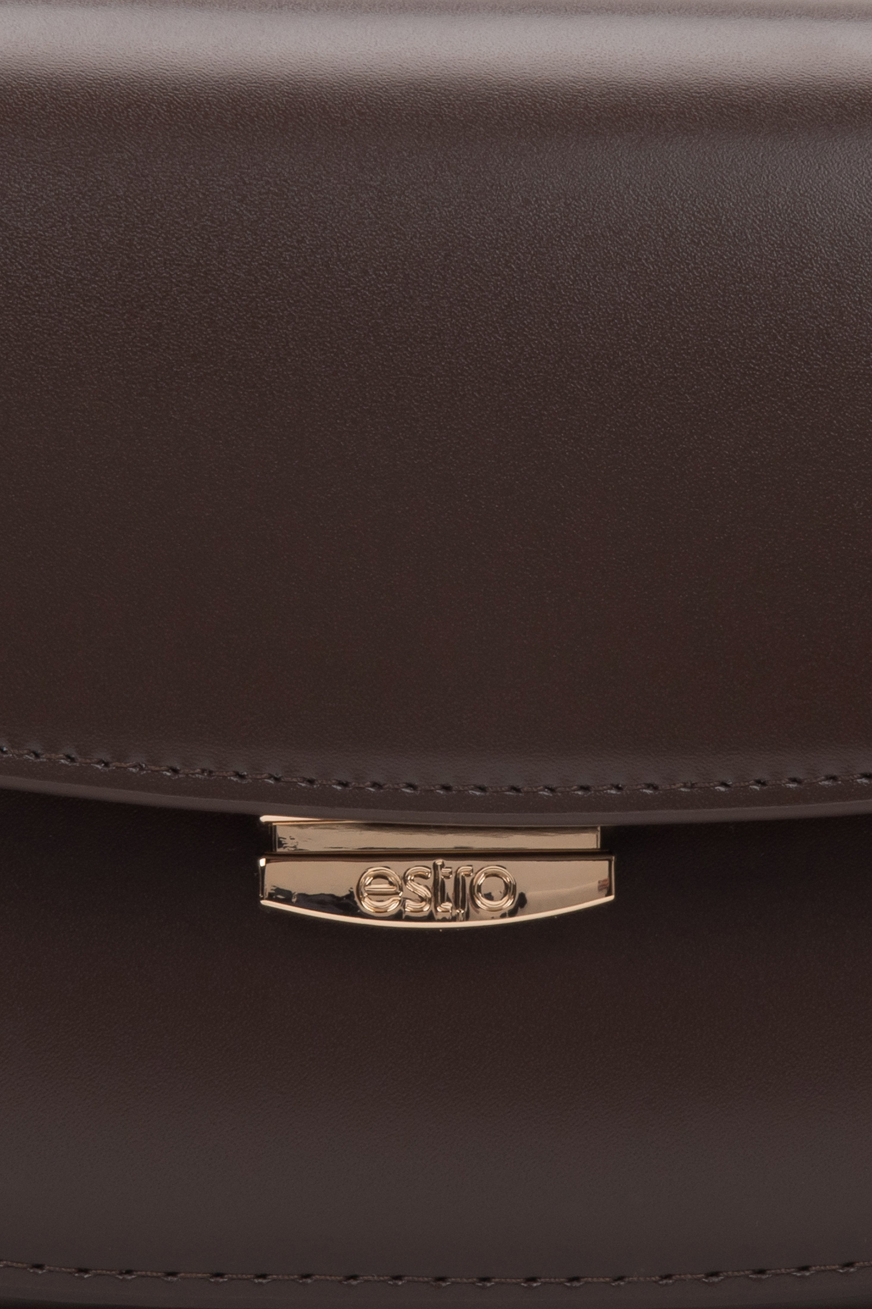 Nahaufnahme des Druckknopfverschlusses der dunkelbraunen Ledertasche.