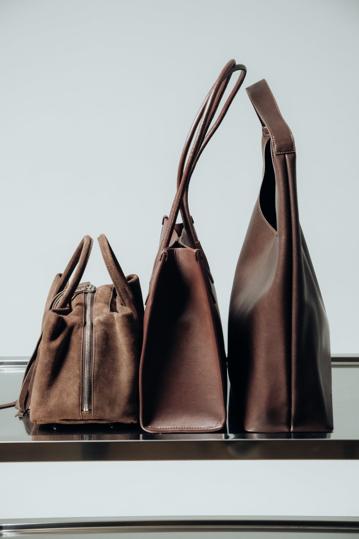 Profil-Größenvergleich verschiedener brauner Damen-Handtaschen aus Glatt- und Veloursleder