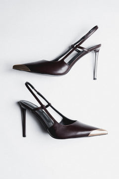 Dunkelbraune Damen-Slingpumps aus Leder als Paar in schräger Seitenansicht mit goldfarbener Spitze