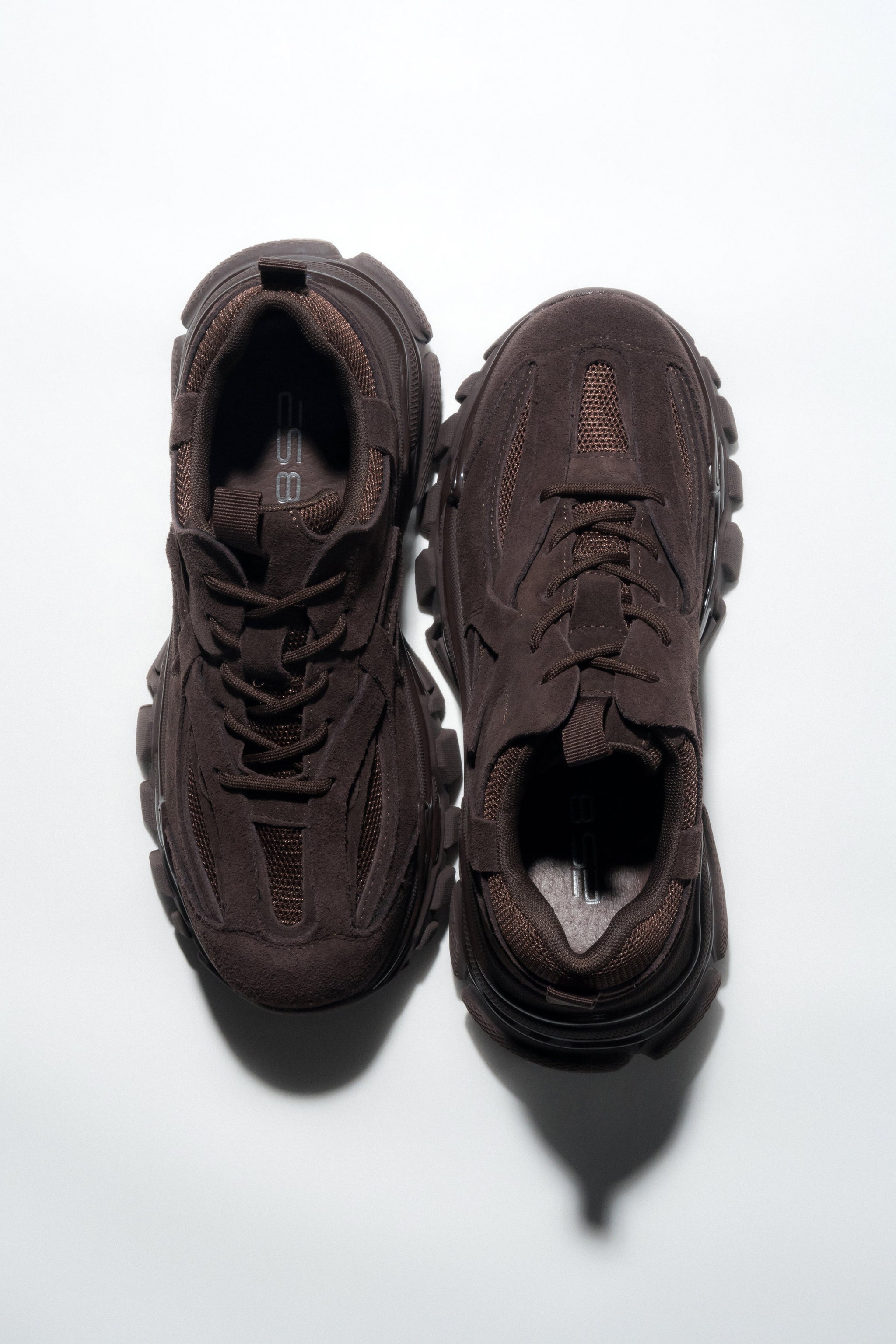Draufsicht auf das Paar dunkelbrauner Damen-Sneaker mit dicker Sohle.