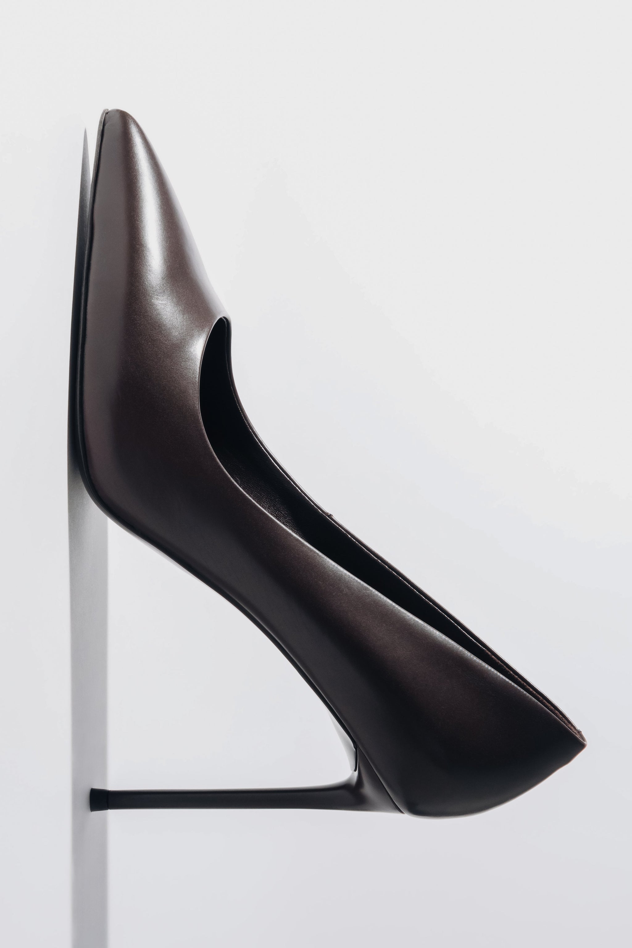 Vertikale Detailaufnahme des dunkelbraunen Stilettos mit Fokus auf die Gummisohle und den feinen Pfennigabsatz 