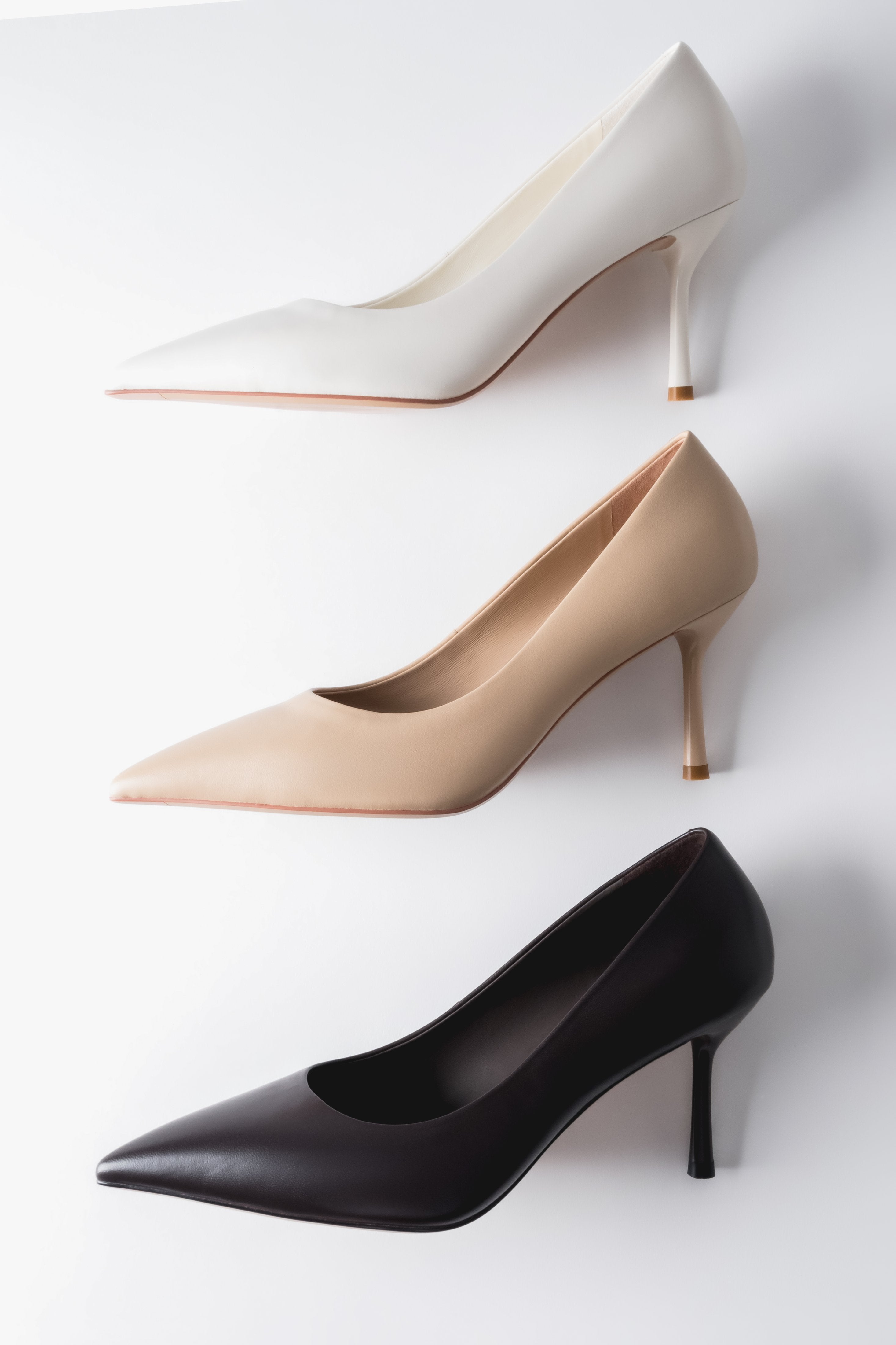 Gruppenaufnahme der Stilettos in drei verschiedenen Farben (Beige, Weiß, Dunkelbraun) im harmonischen Arrangement 