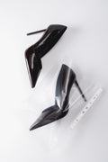 Künstlerische Draufsicht auf das Paar dunkelbrauner Damen-Stilettos aus Lackleder