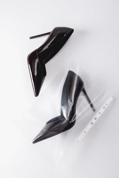 Künstlerische Draufsicht auf das Paar dunkelbrauner Damen-Stilettos aus Lackleder