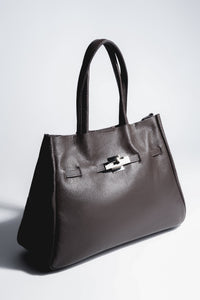 Schrägansicht der dunkelbraunen Damen Tote-Bag aus genarbtem italienischem Echtleder im A4-Format mit kurzen Tragegriffen und silberfarbenem Verschlussdetail
